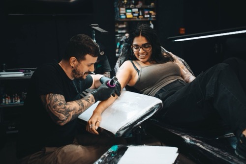 Vivid Ink tattoo artist working on a client